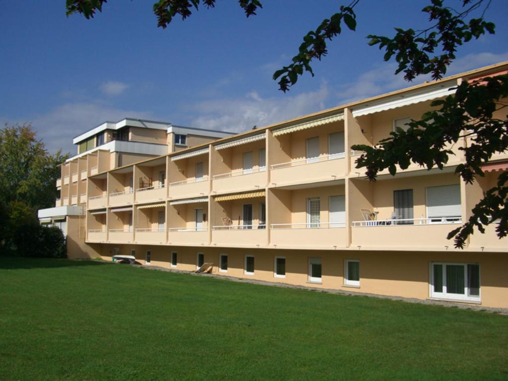 um edifício de apartamentos com um relvado em frente em Ferienwohnung am Kurpark Mettnau em Radolfzell am Bodensee