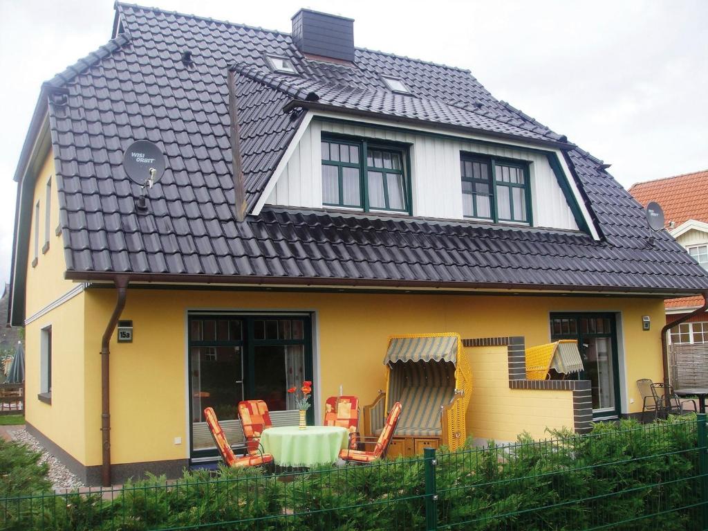 a yellow and white house with chairs and a table at Gödeke Michels 2 in Zingst