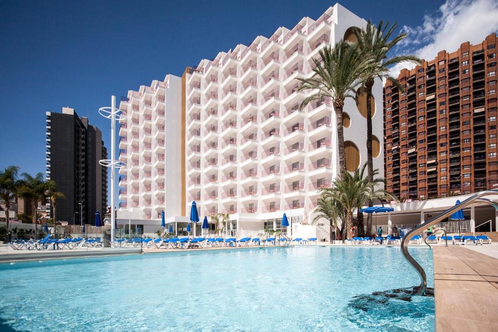 um hotel com piscina em frente a um edifício em Ambassador Playa II em Benidorm