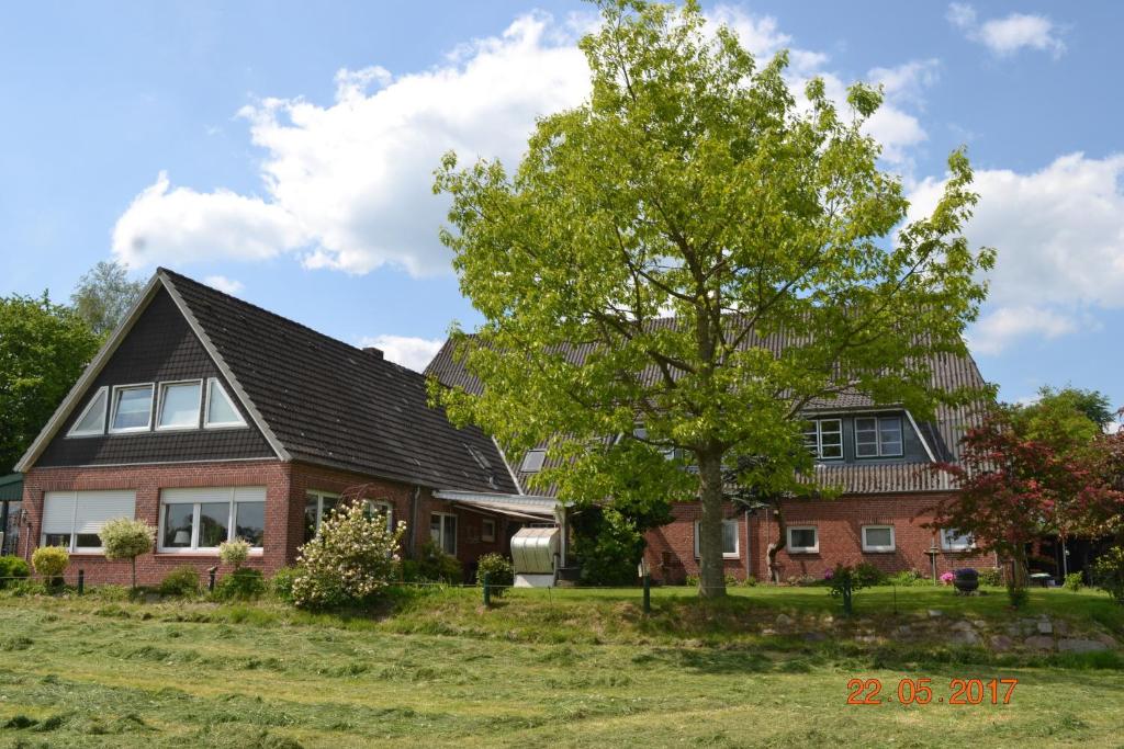 una casa con un árbol delante de ella en Ferienhof Gosch en Rendsburg