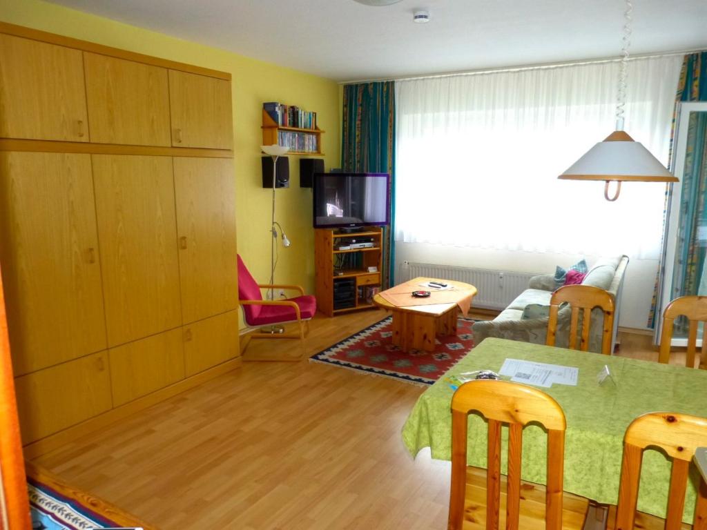 a living room with a dining room table and a living room with a table at Wohnung Nr 2 in Haffkrug
