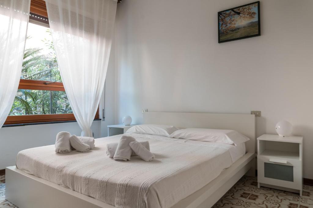 a white bedroom with a large bed and a window at Il Piccolo Gigante in Monterosso al Mare
