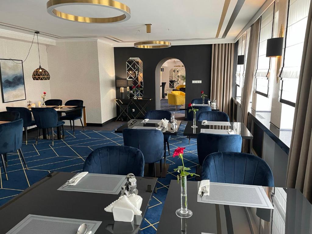 - un restaurant avec des tables et des chaises bleues dans une pièce dans l'établissement Hotel Daria, à Tychy