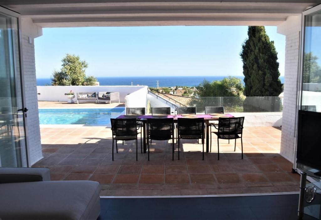 eine Terrasse mit Tisch und Stühlen und einem Pool in der Unterkunft Casa Green in Mijas Costa