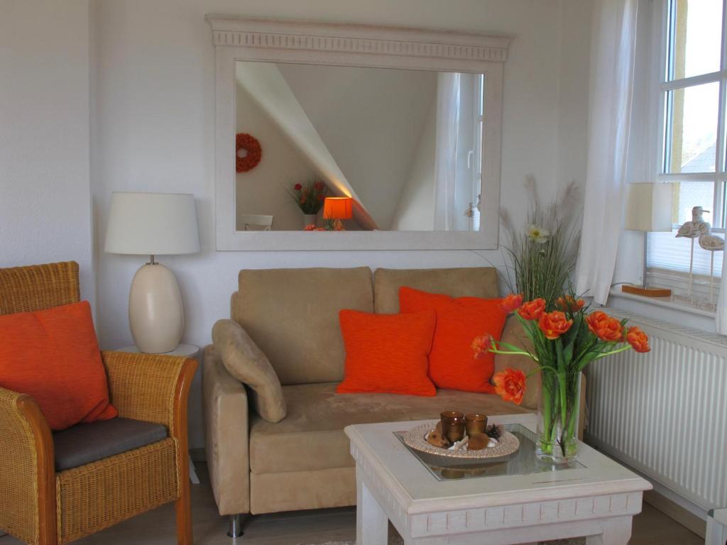 a living room with a couch and a table with orange pillows at Wiesenstraße 55 Whg 2 - Strandbuhne in Zingst