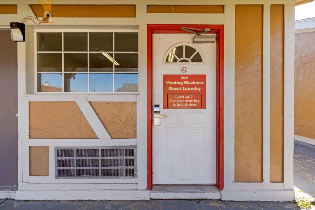 une porte d'entrée d'un bâtiment avec un panneau sur celui-ci dans l'établissement Econo Lodge, à Pryor