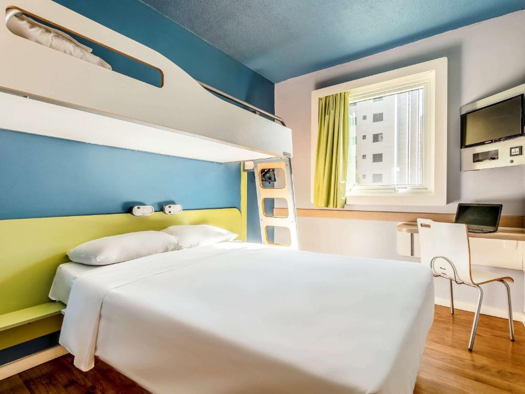 1 dormitorio con 1 cama blanca grande y escritorio en ibis budget Belo Horizonte Afonso Pena en Belo Horizonte