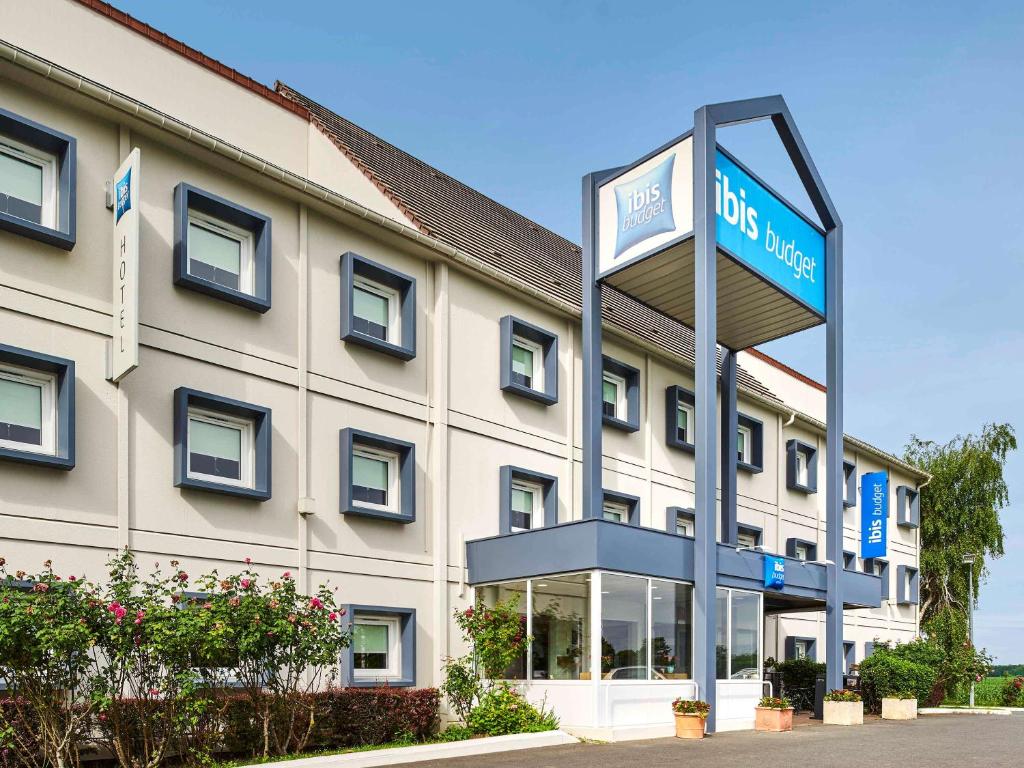 a hotel with a sign in front of a building at ibis budget Santeny in Santeny