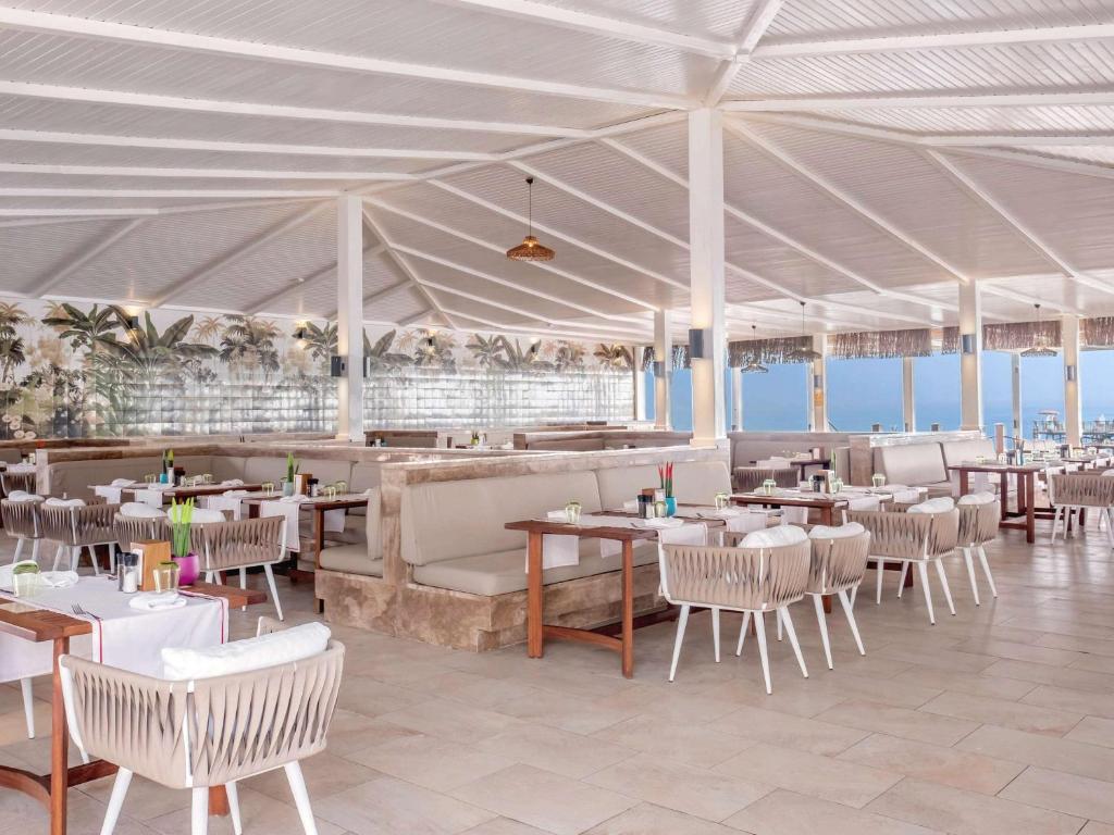a restaurant with tables and chairs and a white tent at Rixos Sungate - The Land of Legends Access in Beldibi