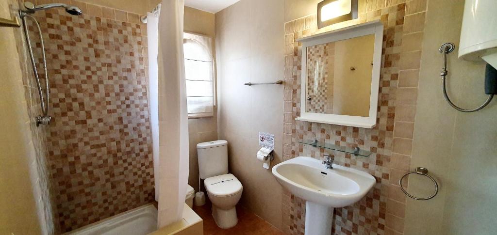 a bathroom with a sink and a toilet and a mirror at Granada Apartments Familiar Deluxe in Portinatx