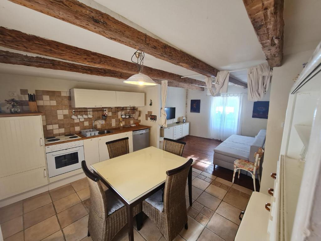 une cuisine et un salon avec une table et des chaises dans l'établissement Seabed Apartma 1, à Piran