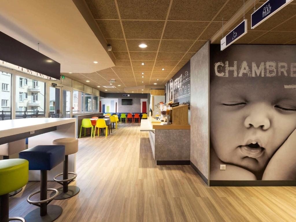 a restaurant with a baby face on the wall at Ibis Budget Bourgoin Jallieu Centre in Bourgoin