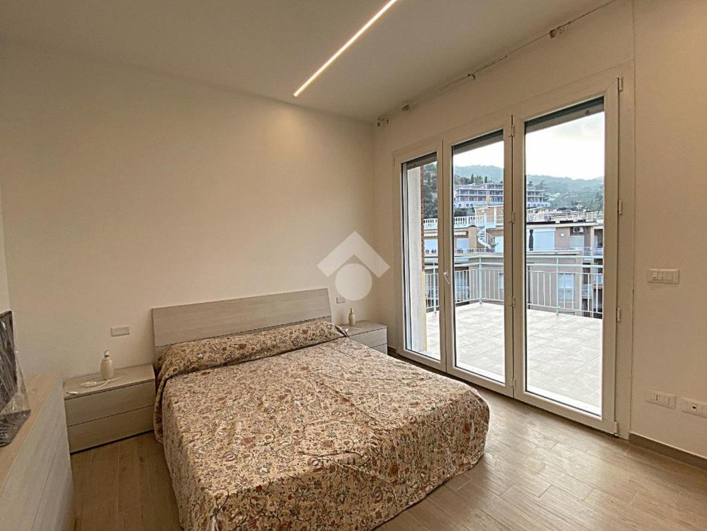 a bedroom with a bed and a large window at residence cristallo in Alassio