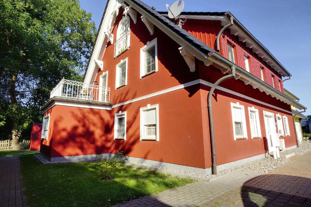 a red building with a balcony on the side of it at Villa Arielle, FW 5 in Zingst