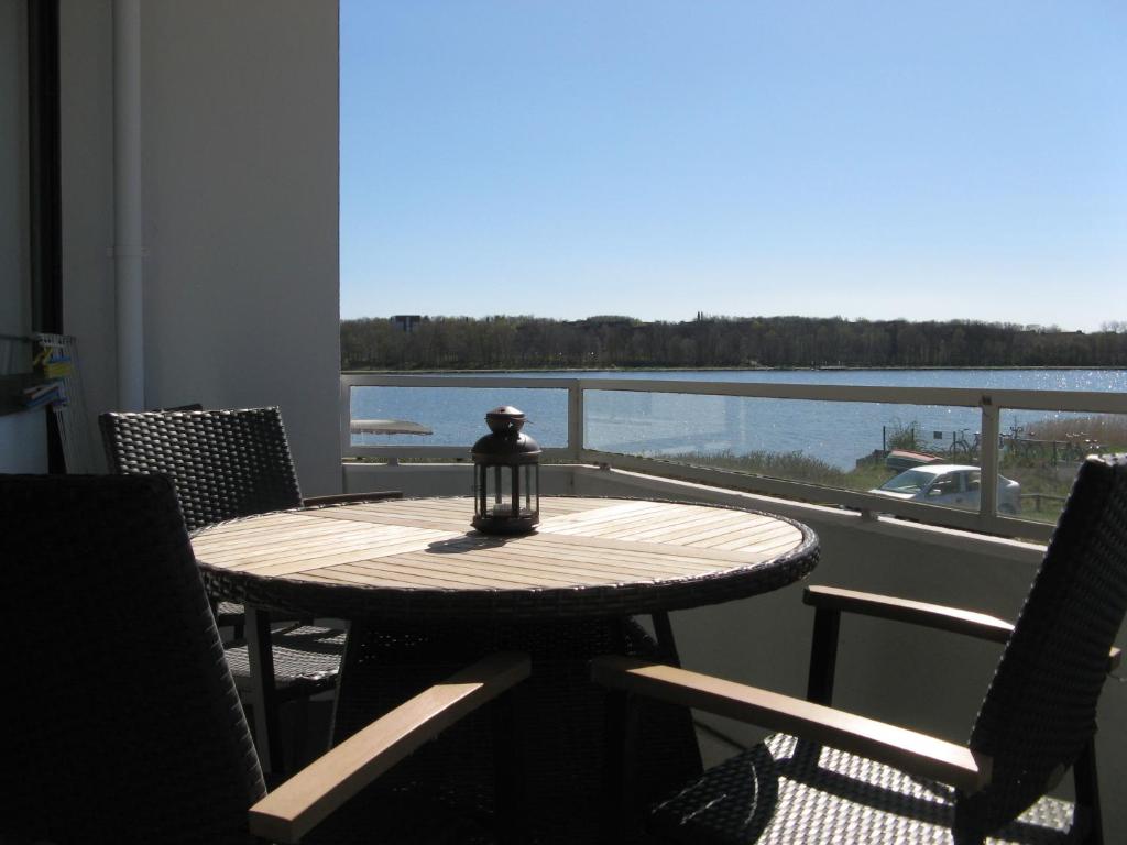 a table and chairs with a view of the water at Ferienwohnung, Steinwarder 9 in Heiligenhafen