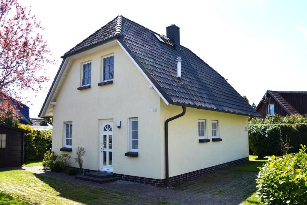 a white house with a black roof at Haus Birnbaum in Zingst