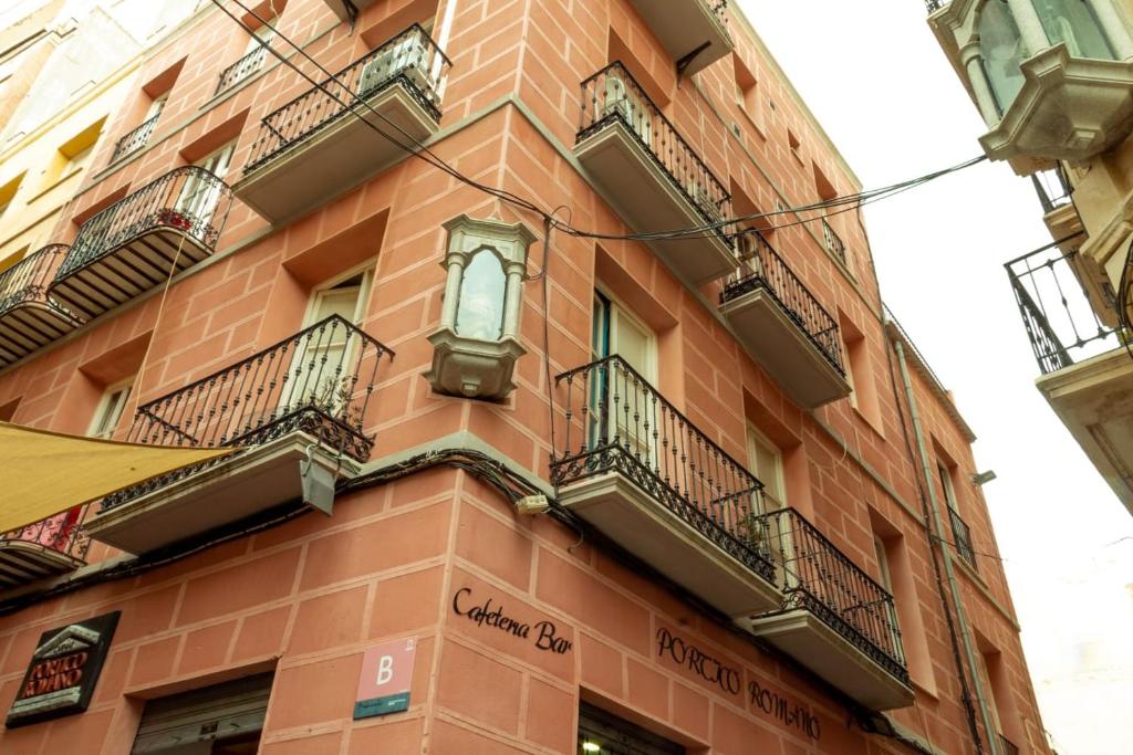 a red brick building with balconies on a street at Apartamento Ene one in Cartagena