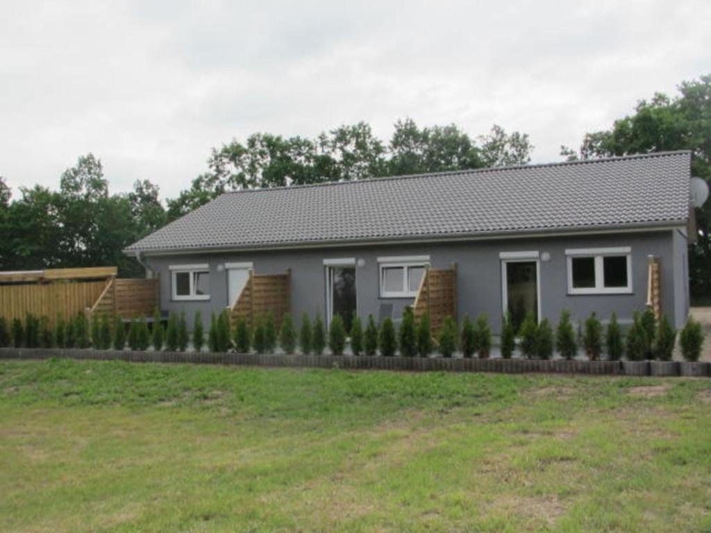 a house with a landscaping in front of a yard at Barons Ferienappartement A in Dargun