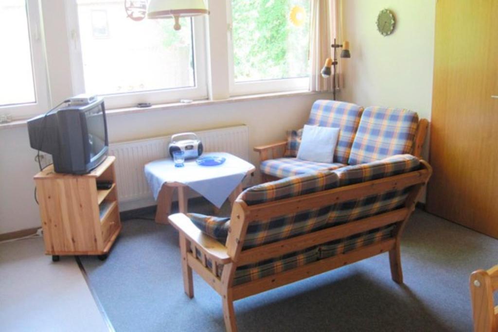 Dänschendorf的住宿－Ferienhof Ralf Becker Nr3，带沙发、电视和桌子的客厅
