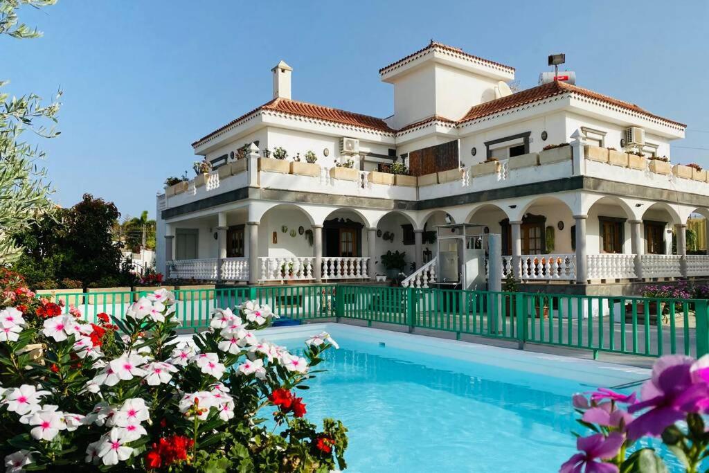 een groot huis met een zwembad en bloemen bij 2 Apartments with private pool at Villa Diaz Aleman in Salobre