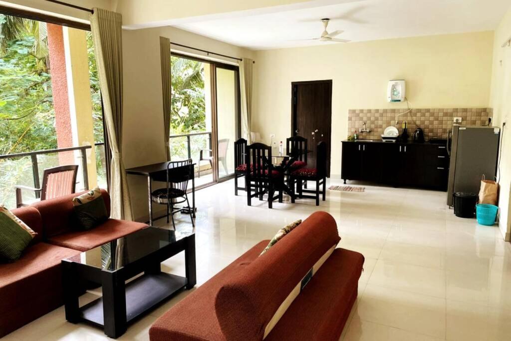 Mango Apartment @ Palolem Garden Estate في محطة كاناكونا: غرفة معيشة مع أريكة وطاولة