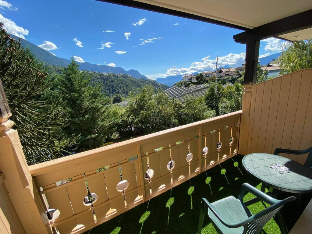 a balcony with a table and chairs and mountains at Laimerhof in Rifiano