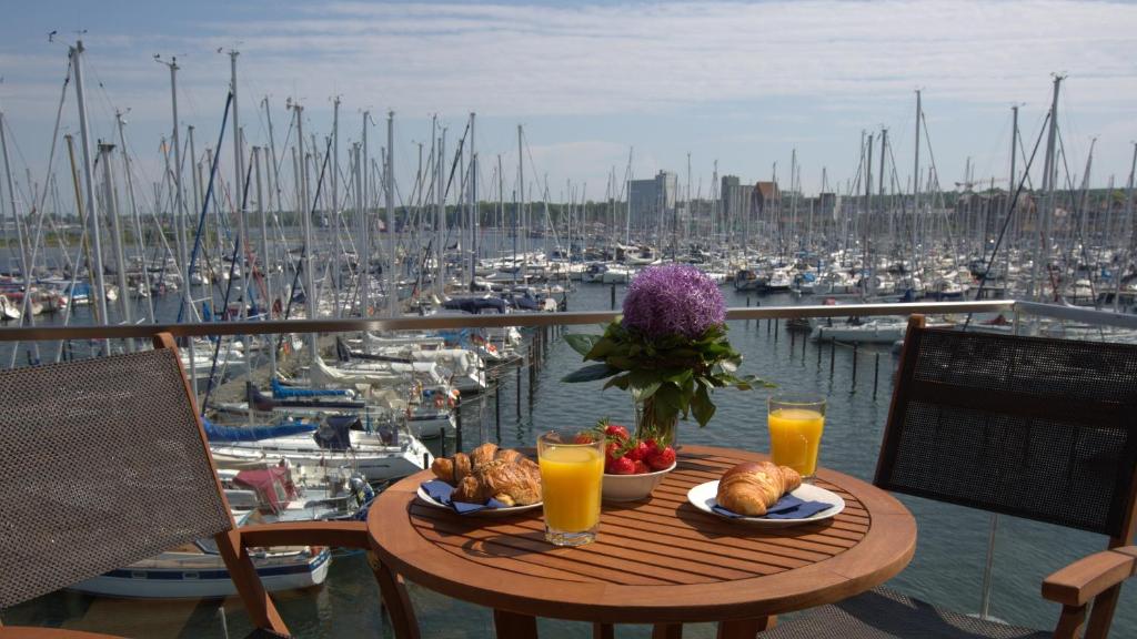 a table with food and drinks on a balcony with a marina at Ostsee - Appartement Nr 52 "Seglerlounge" im Strand Resort in Heiligenhafen