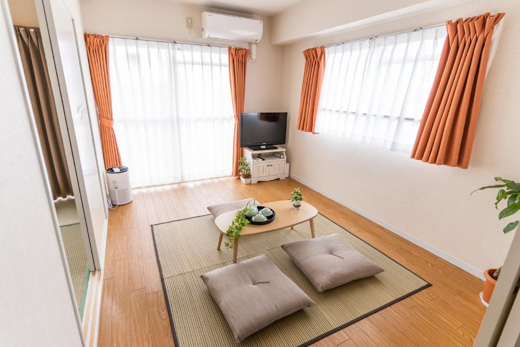 a living room with a table and a tv at stay's ジローズ浄心 601号 名古屋 民泊 駅近 in Nagoya