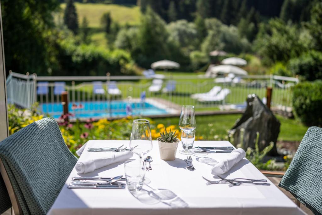 una mesa con mantel blanco y copas de vino en Hotel Sonnalm en Bad Kleinkirchheim