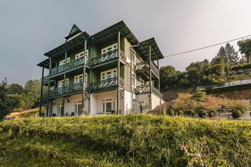 une grande maison au sommet d'une colline dans l'établissement Willa Tęcza, à Szczawnica