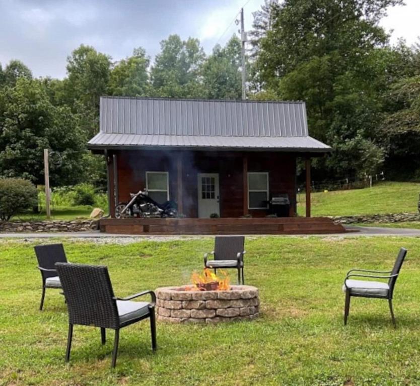 a group of chairs sitting in front of a cabin at Dragon's Nest Cabin with Mountain Views in Robbinsville