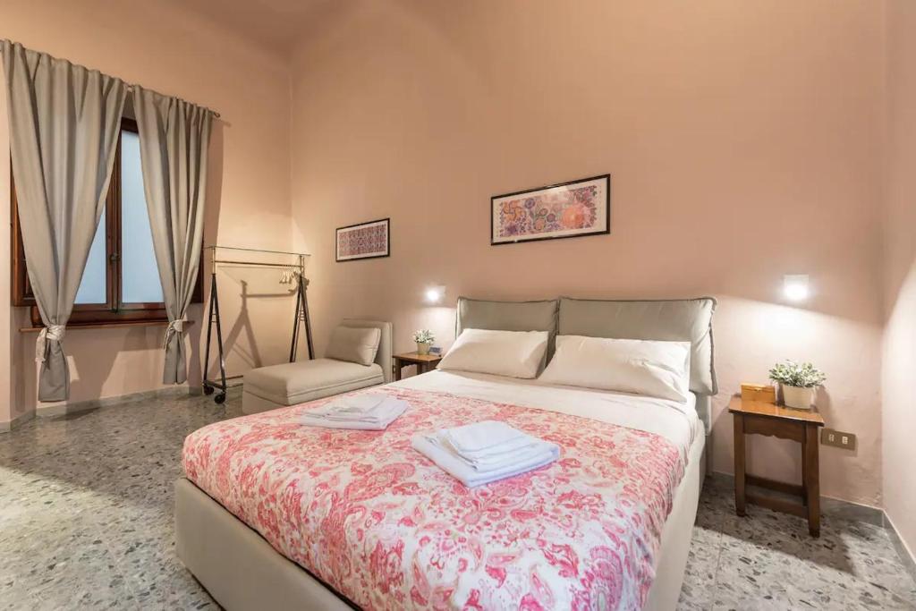フィレンツェにあるVia Roma 4 Homeのベッドルーム(大型ベッド1台、椅子付)