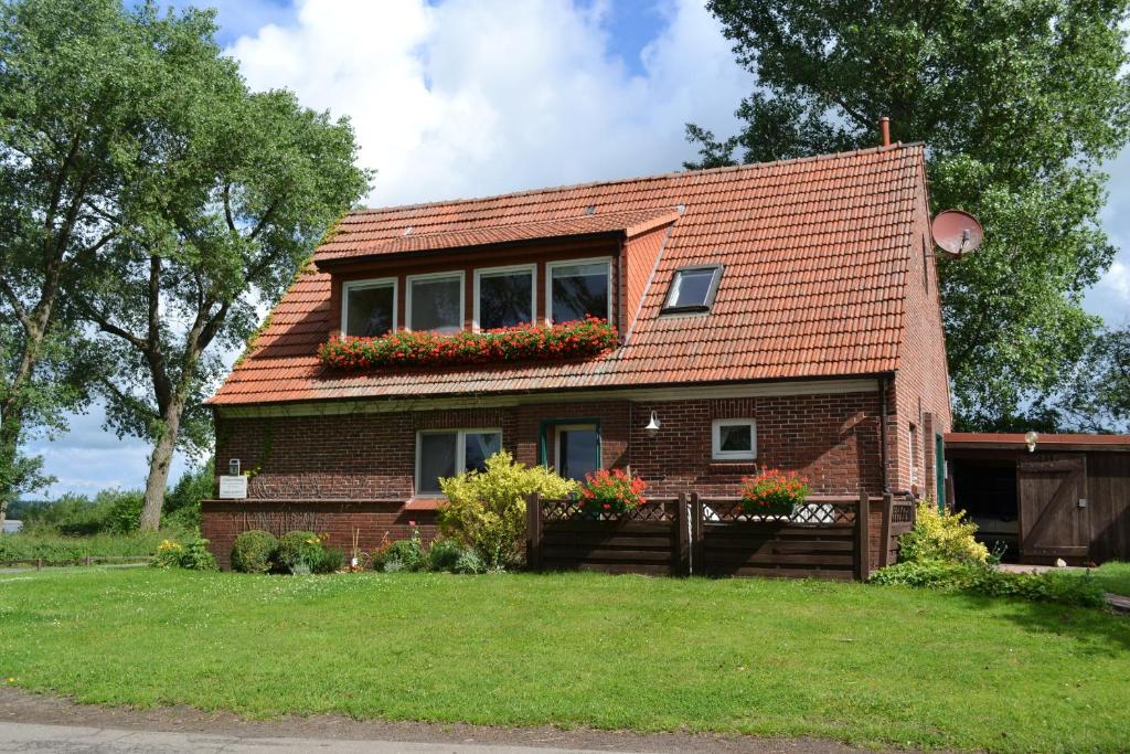 une petite maison en briques avec des fleurs à la fenêtre dans l'établissement Inselhof Steengrafe - Weserblick, à Schwanewede