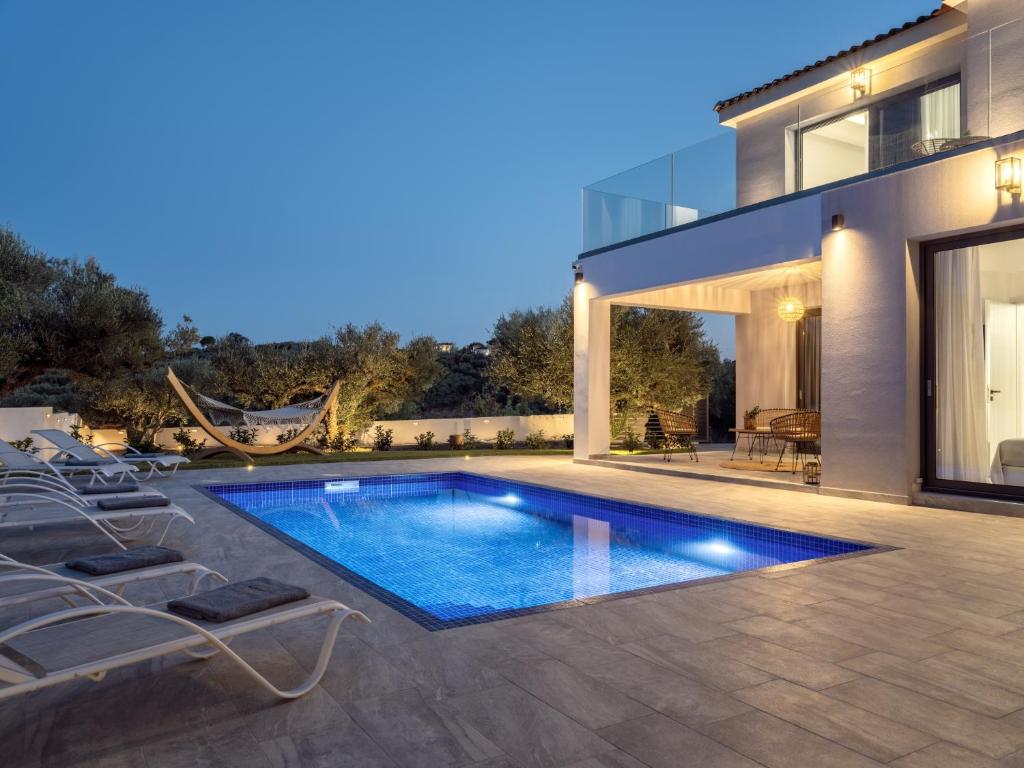 a swimming pool in the backyard of a house at Kapodistria Luxury Villas in Plános