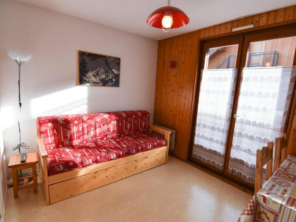 Habitación con sofá rojo y ventana en Studio Valloire, 1 pièce, 4 personnes - FR-1-263-6 en Valloire