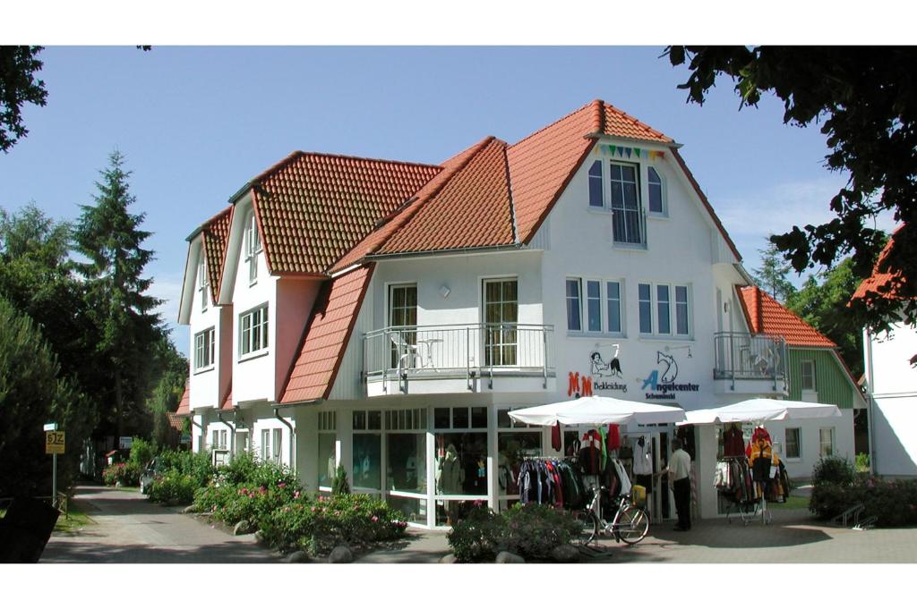 a large white building with a red roof at Wohnung Central FW 4 mit Balkon in Zingst