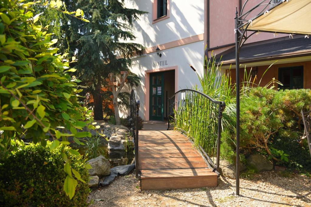 a wooden walkway leading to a building with a door at Hotel and restaurant Via Ironia in Vysoké Mýto