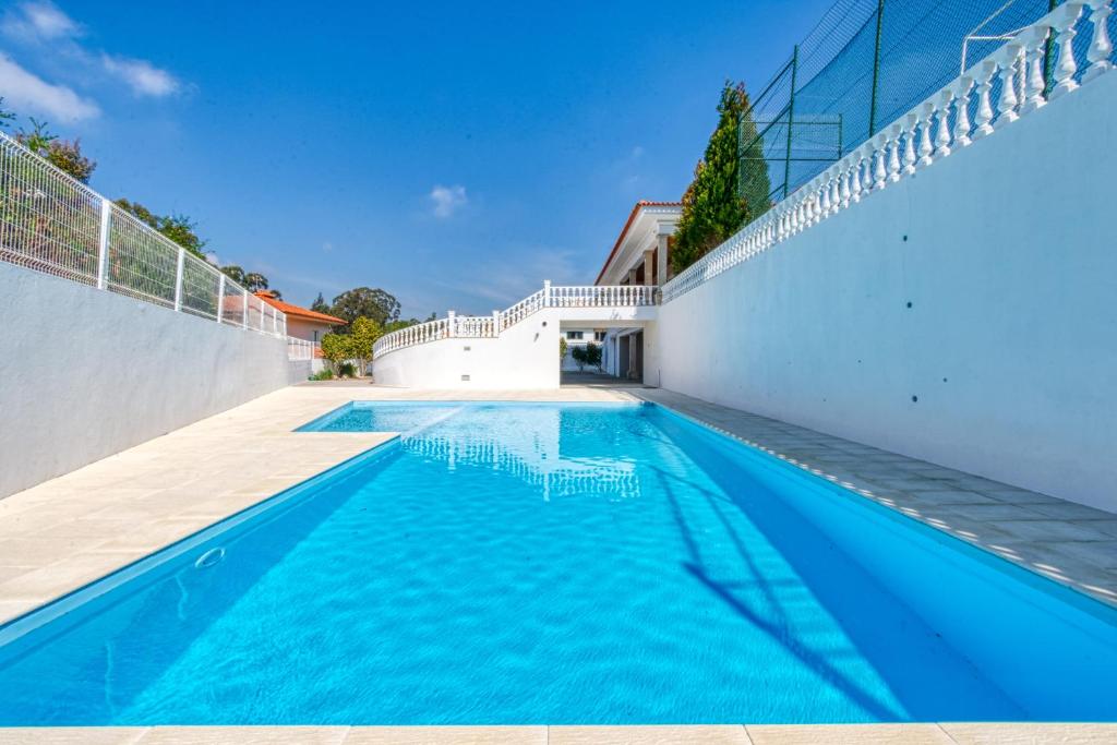 a swimming pool in the backyard of a house at A Tal Casa in Paços de Brandão