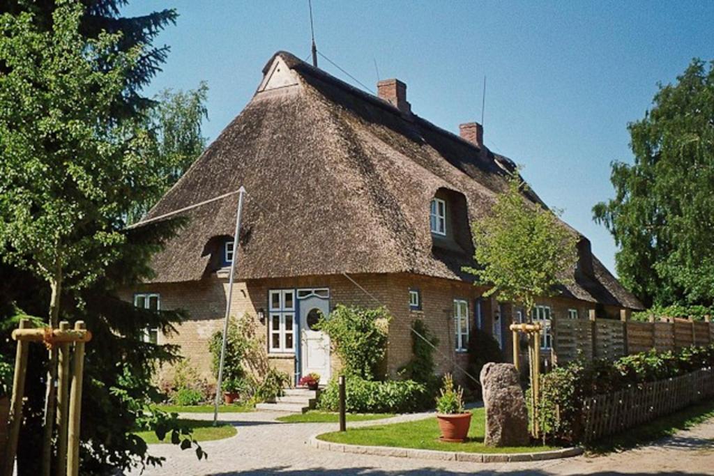 a large brick house with a thatched roof at Altes Rektorenhaus 1 in Rieseby
