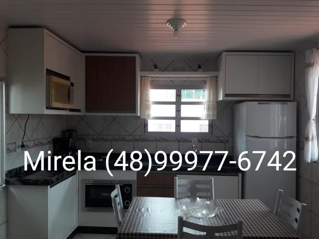 una cocina con mesa y ventana. en Apartamento Praia dos Ingleses, 100 mt do mar, en Florianópolis
