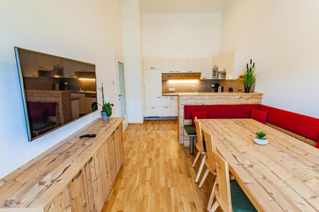 a living room with wooden tables and a red couch at Happy Aich 4 by Alpenidyll Apartments in Aich