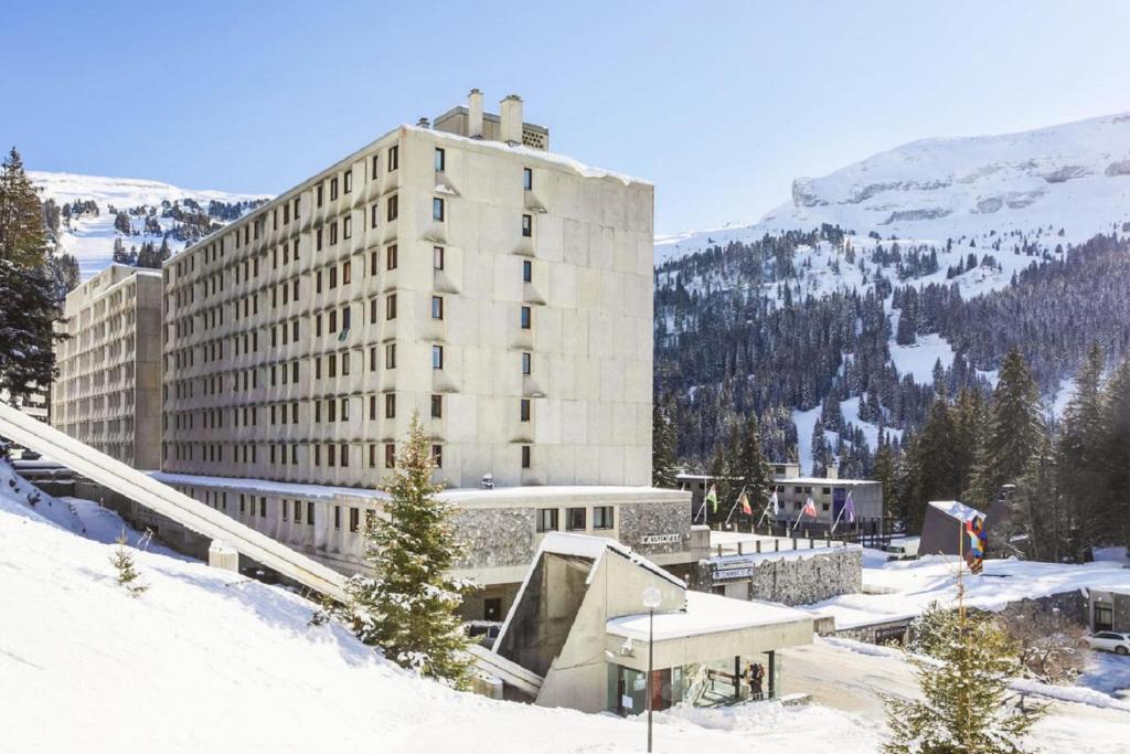 un grand bâtiment dans la neige devant une montagne dans l'établissement Residence Cassiopee - maeva Home, à Flaine