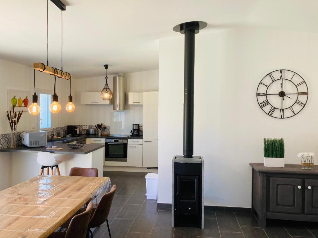 eine Küche und ein Esszimmer mit einem Holzofen in der Unterkunft Maison de la forêt, terrasse plein sud et standing in Saint-Jean-de-Monts