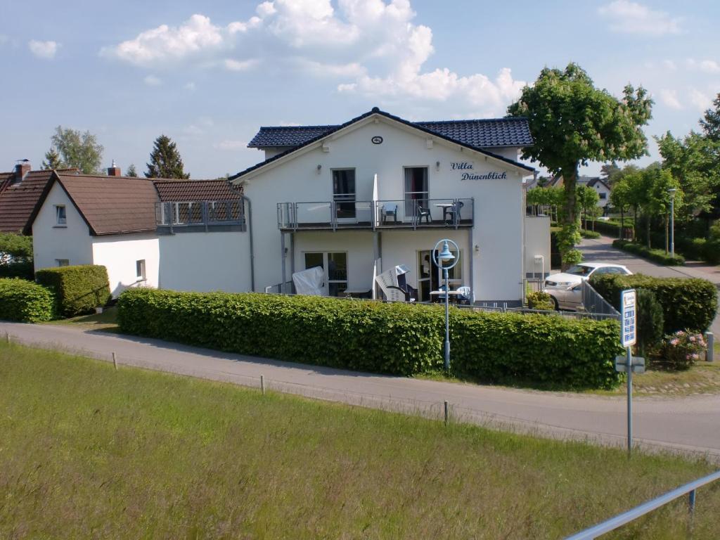 a white house on the side of a road at Villa Dünenblick 02 in Zingst