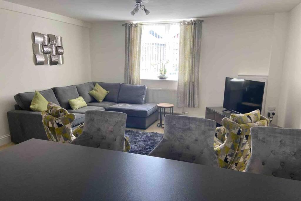 ウルバーストンにあるUlverston South Lakes Spacious 3 Bed G/F Apartmentのリビングルーム(ソファ、テーブル、椅子付)