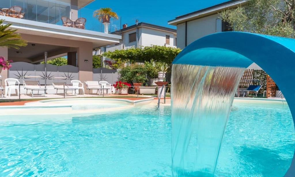 a pool with a water fountain in the middle at Hotel Benaco in Sirmione