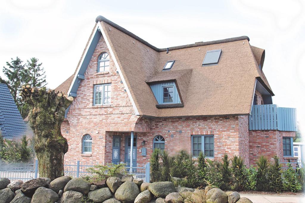 a brick house with a tree in front of it at Residenz Rosenberg FW 3 in Zingst