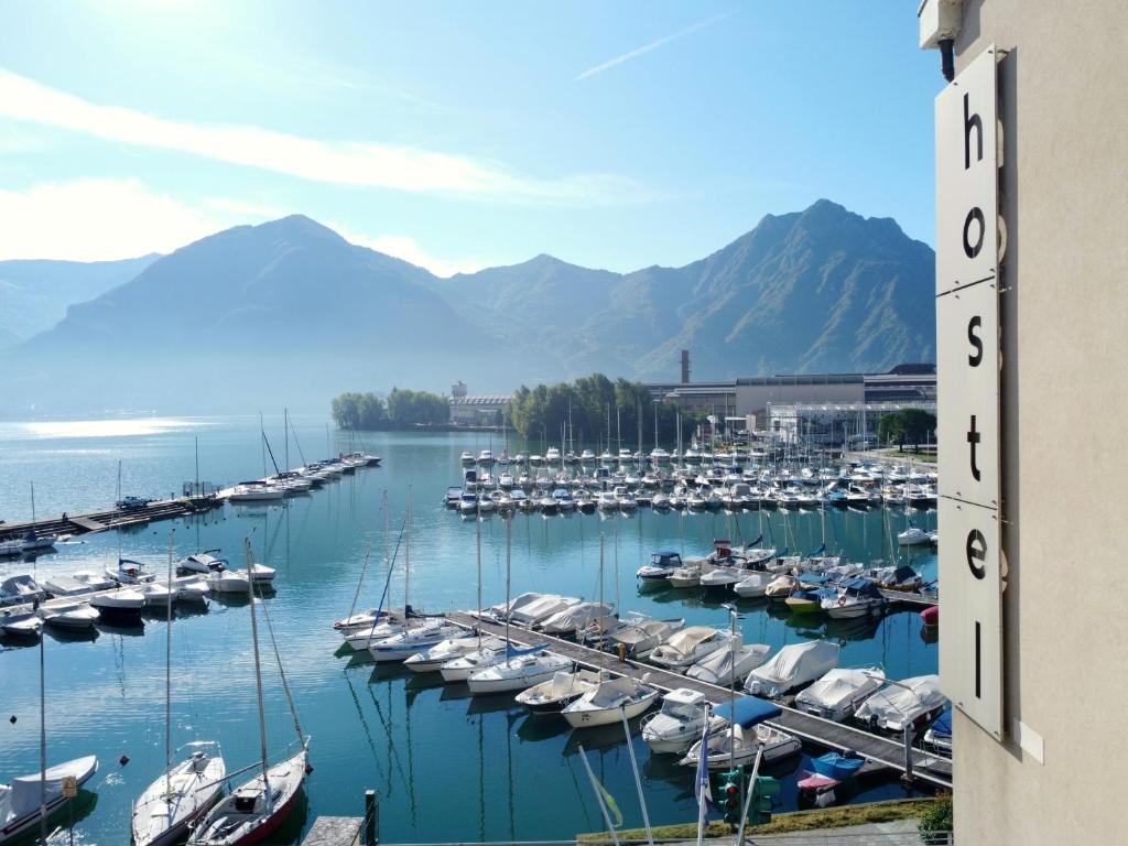 a group of boats docked in a marina with mountains at Ostello Del Porto in Lovere