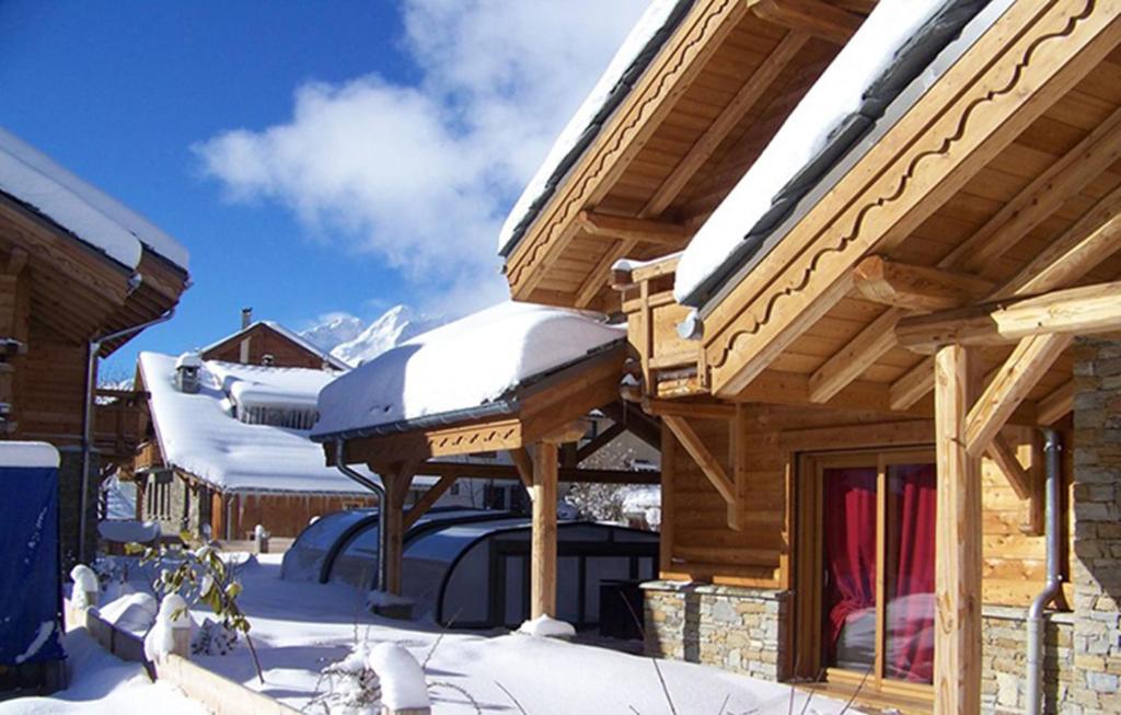 una cabaña de troncos con nieve en el techo en Odalys Chalet Le Loup Lodge, en Les Deux Alpes