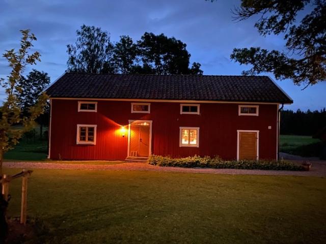 Czerwona stodoła ze światłem na górze w obiekcie Albäck Gård Bagarstugan - Granne med Sala Golfklubb w mieście Sala